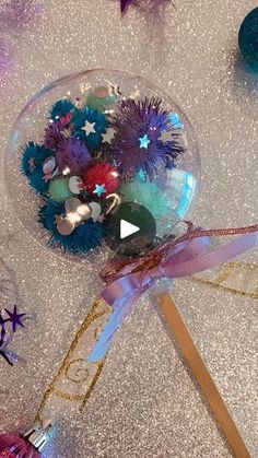 a glass bowl filled with colorful ornaments on top of a table