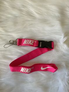 Keep your keys safe and stylish with this pink Nike lanyard. Made from high-quality materials, this lanyard is perfect for any occasion. Whether you're headed to the gym or just running errands, the Nike logo and vibrant color will make a statement wherever you go.  Ideal for anyone who wants to keep their keys organized and easily accessible, this lanyard is a must-have accessory. The durable construction ensures that it will last for years to come, and the pink color is sure to brighten up any Nike Lanyard, Nike Style, Nike Gold, Everyday Routine, Key Organizer, Pink Nike, Pink Nikes, Wristlet Keychain, Nike Fashion