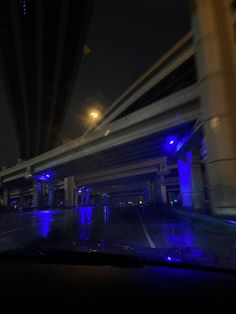 a car driving down the road at night with blue lights on it's windshield