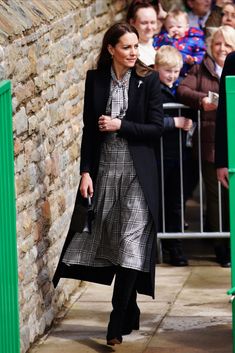 the duke and princess of cambridge are seen walking through an area with people watching them