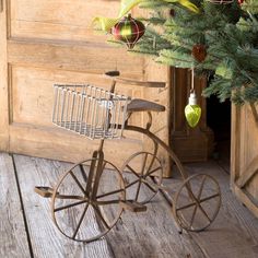 an old fashioned bicycle is next to a christmas tree