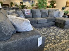 a living room filled with furniture and lots of pillows on top of the couches