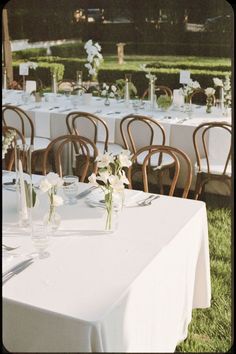 tables set up with white tablecloths and flowers in vases