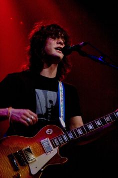 a young man playing an electric guitar on stage