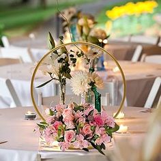 an arrangement of flowers and greenery is displayed on the tables at a wedding reception