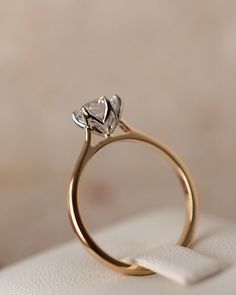 an engagement ring with a heart shaped diamond sits on top of a white cloth napkin