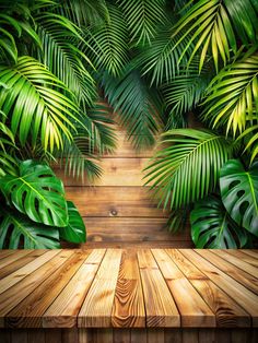 a wooden table topped with lots of green palm leaf covered wall art prints on the walls