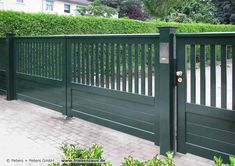 a green fence with white pickets on it