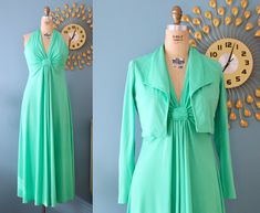 "A fantastic matching set that consists of a green sleeveless maxi dress and a cropped, long-sleeve jacket. The fullness of the skirt gathers at a diamond below the bust. Has a bit of a halter neckline without an open back. The collared jacket has a slight \"moto\" style to it. The dress fastens with a zipper and two hooks in the back and the jacket has no closures. -- Measurements: ** All measurements are taken flat and then doubled where necessary. ** Shown on a size small dress form with 35\" Fitted 1970s Style Green Maxi Dress, 1970s Fitted Green Maxi Dress, Green Fitted Maxi Dress 1970s Style, 1970s Style Fitted Green Maxi Dress, 70s Maxi Dress, Collared Jacket, Green Maxi, Moto Style, Sleeve Jacket