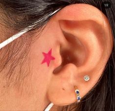 a woman with a pink star tattoo behind her ear