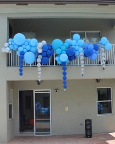 blue and white balloons are hanging from the balconies