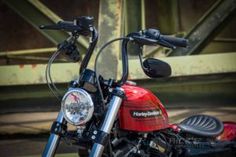 a red motorcycle parked next to a bridge