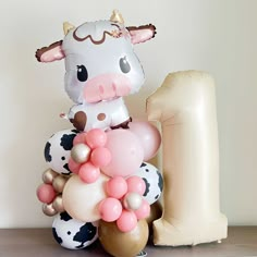 Cute cow balloon tower for baby shower and birthday party decorations in rose, sand, coffee and cow print with flower daisies and a coordinating number balloon Brown And Pink Cow Party, Cow Birthday Balloons, Cow Themed Birthday Party Centerpieces, Strawberry Cow Birthday Party, Cow Birthday Centerpiece, Pink Cow Birthday Party Ideas, Bunny Second Birthday Party, First Rodeo Decorations, Vaca Lola Party Decoration