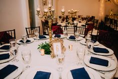 the table is set with blue napkins and place settings for an elegant dinner party