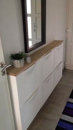 there is a plant on top of the dresser in this room with blue and white rugs