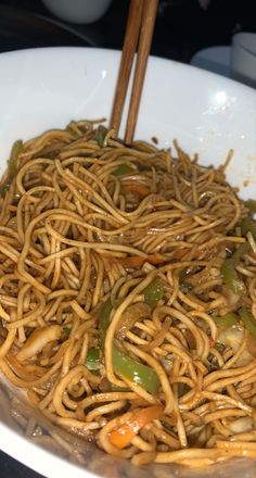 a white bowl filled with noodles and vegetables