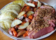 a white plate topped with meat and veggies on top of a wooden table