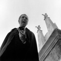 a man standing in front of three statues making the v sign with his hands and fingers