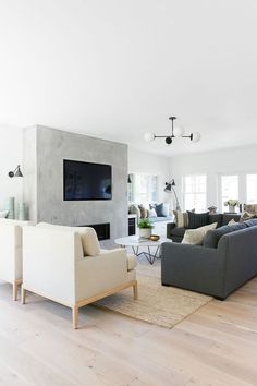 a living room filled with lots of furniture and a flat screen tv mounted on the wall