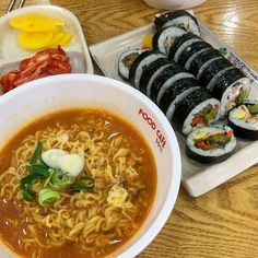 a bowl of ramen with chopsticks and other food items on the side