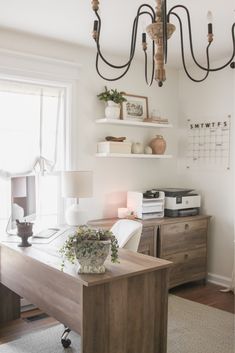 a room with a desk, lamp and shelves on the wall