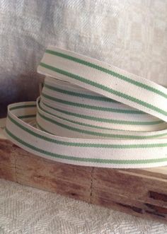 a white and green striped ribbon on a piece of wood