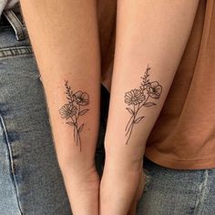 two people with matching tattoos on their arms holding each other's hands and one has a flower tattoo on her left arm