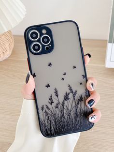 a woman is holding up her phone case with butterflies flying over the grass on it