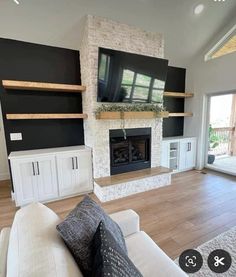 a living room with white furniture and a flat screen tv mounted on the wall above a fireplace