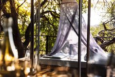 a bed sitting on top of a wooden floor next to a window covered in mosquito netting