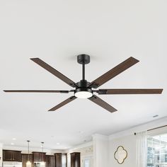 a ceiling fan in the middle of a living room with wood floors and white walls