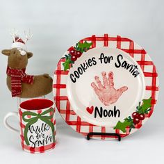 a christmas themed plate and mug with handprints on it