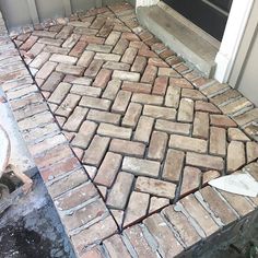 a brick walkway being laid in front of a door