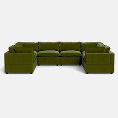 a green sectional couch sitting on top of a white floor