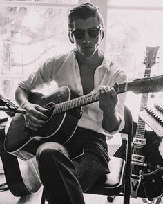 a man sitting in a chair holding a guitar