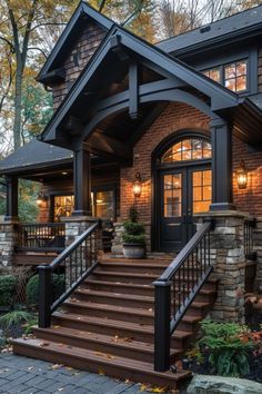 a house with stairs leading up to the front door and entry way, surrounded by trees