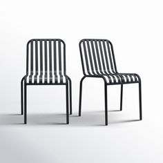 two black and white chairs sitting next to each other on a white surface with one chair facing the camera