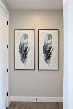 two paintings hanging on the wall in a hallway