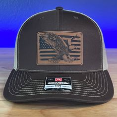 American Flag Eagle patch hat Specifications: 🧢 SnapBack Trucker Hat; adjustable for the perfect fit 🎩 Cotton/polyester blend for comfort 📏 One size fits most 🏷️ Expertly laser engraved leatherette patch design 📦 Ships in 2 to 3 business days from our Orlando Studio Care Instructions: 🚫 Do not wash; spot clean only Please Note: 🌈 Colors may vary from photos based on your viewing screen. Orlando Studios, Leather Patch Hat, Engraved Tumblers, American Flag Eagle, Entertaining Gifts, Patch Hat, Funny Hats, Patch Design, Leather Patches