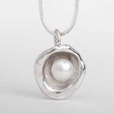 This "Aruba" pearl pendant necklace is handmade of 925 Sterling Silver. It has been hand crafted and cast in pure 92.5% solid silver in my workshop using a technique called water casting. I melt silver and pour the molten silver into cold water! The resulting organic shape creates a cup that imitates nature in a beautiful way. Finally, the lovely cultured pearl is set inside the cup to create this unique pendant.Pearl color: white Pendant size: approx 3/4 inch (20 mm) diameter The pendant hangs Handmade Silver Pearl Necklace With Round Pendant, Unique Sterling Silver Pearl Necklace Gift, Handmade Sterling Silver Pearl Pendant Necklace, Handmade Sterling Silver Pearl Necklace In Silver, Handmade Sterling Silver Pendant Pearl Necklace, Handmade Sterling Silver Pearl Necklace With Round Pendant, Dark Siren, Silver Clay, Wax Carving