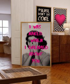 there is a poster on the wall next to a table with a sign that says i was naked when i dared about you