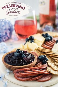 an appetizer platter with blueberries, crackers, cheese and grapes