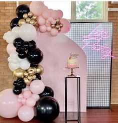 a table topped with balloons and a cake