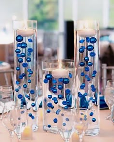 blue and white centerpieces with candles on a table