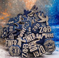 a pile of blue and white badges sitting on top of a table next to snow