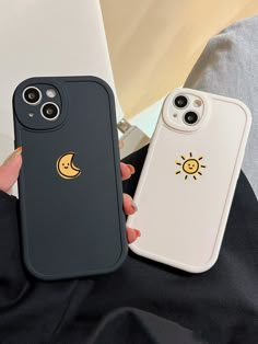 two phone cases with sun and moon stickers on the back one is black, the other is white