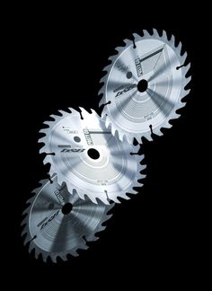 two circular saws sitting side by side on a black background