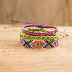 three bracelets on a wooden table with one beaded and the other handmade