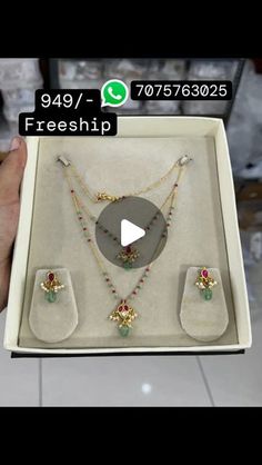 a person holding up a box with jewelry in it