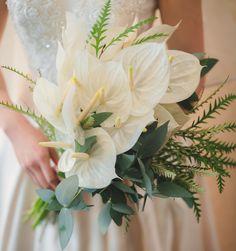 a bride holding a bouquet of white flowers